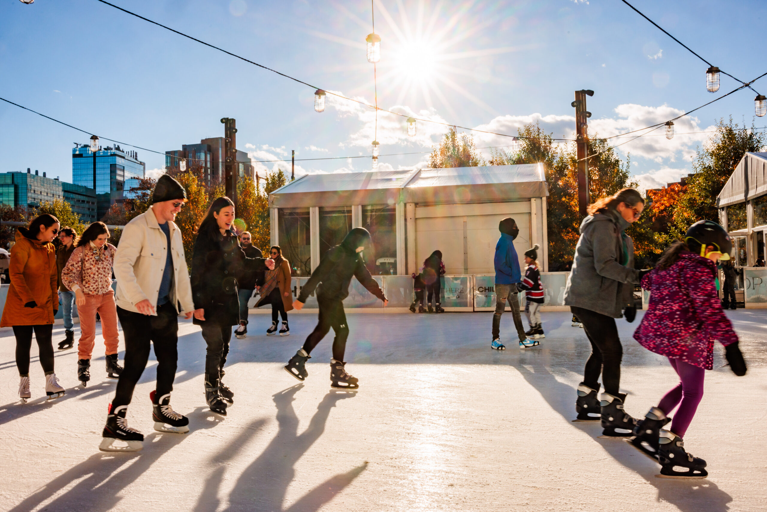 A group of people skating on an ice rink.